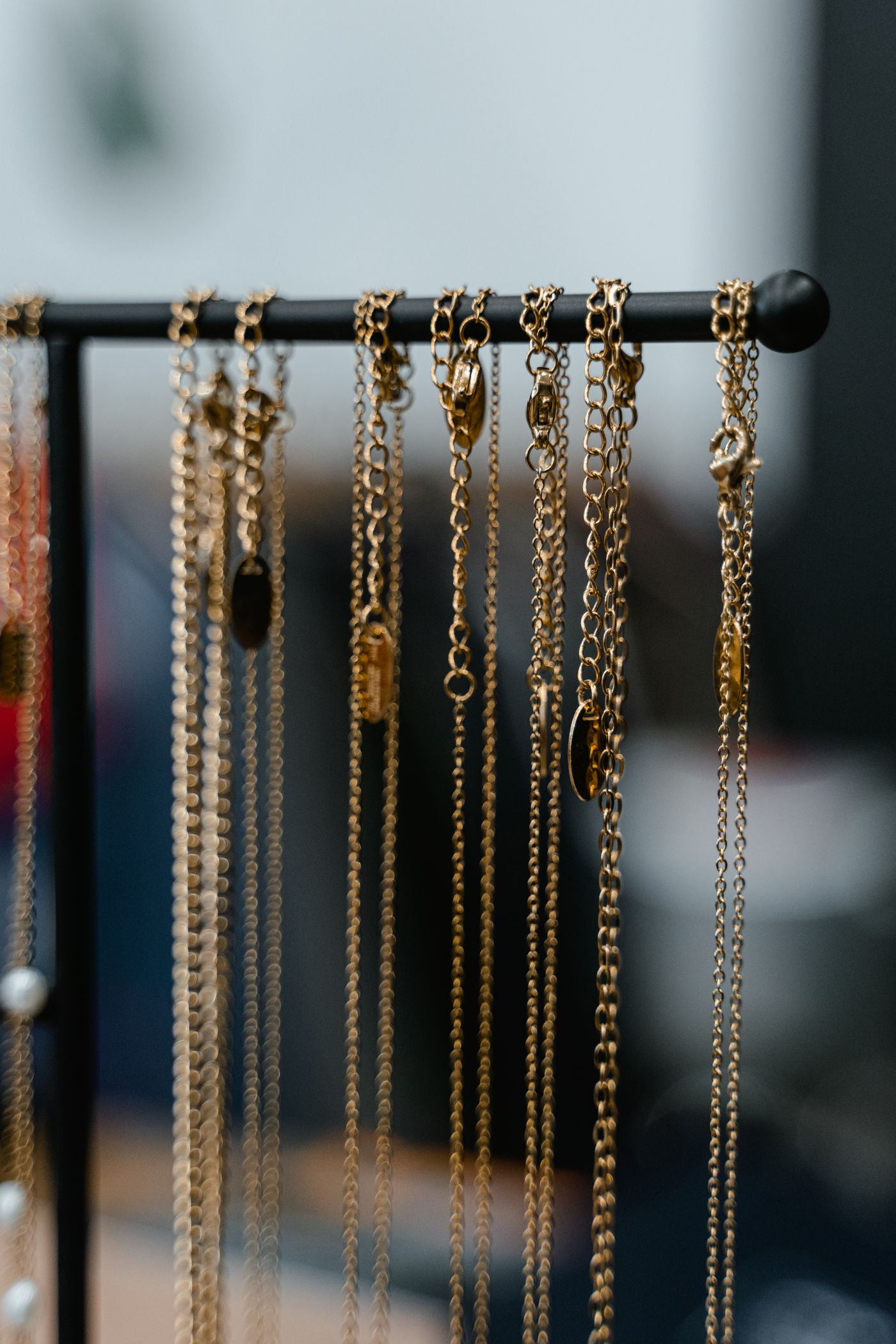 Gold chain necklaces hanging from a rack