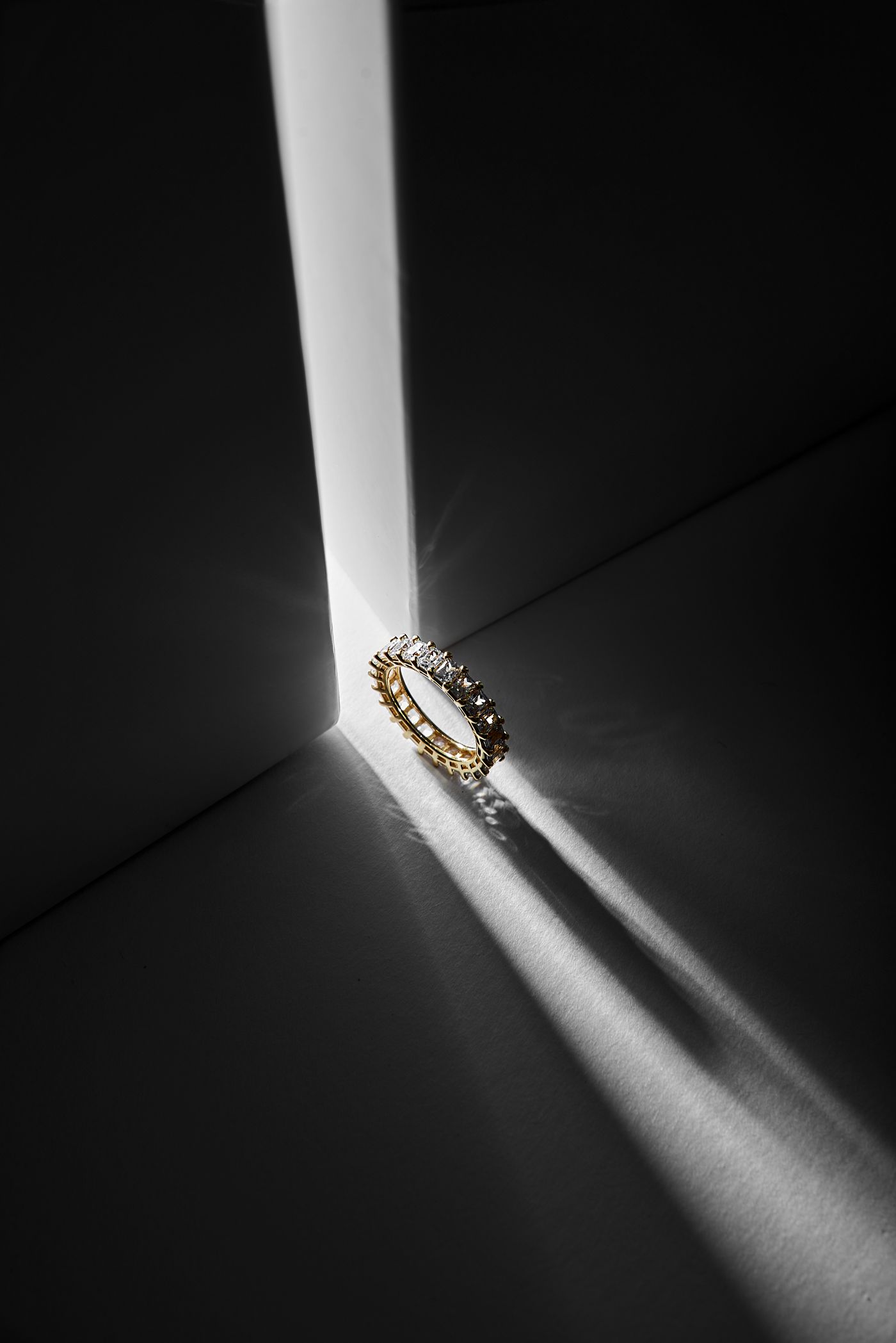 A slim pavé ring standing in a blade of light